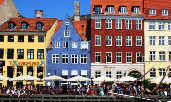 nyhavn-copenhagen-colourful-houses-waterfront-tourists-sunbathing-ambassador-cruise-line-nordic-treasure-cruises-2022
