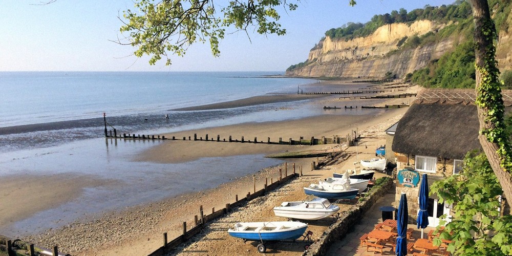 shanklin-beach-with-boats-beach-pub-cliffs-sunny-day-isle-of-wight-best-british-seaside-towns-2022