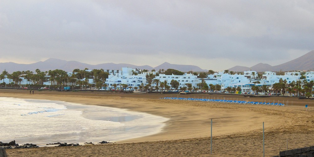 golden-sand-beach-sunset-whitewashed-town-lanzarote-canary-islands-spain