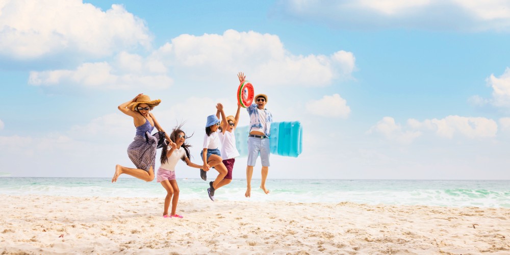 tripbeat-holiday-deals-family-jumping-for-joy-sunny-beach