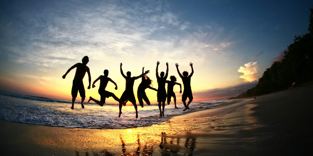 teenagers-jumping-tropical-beach-sunset-luxury-holiday-2023