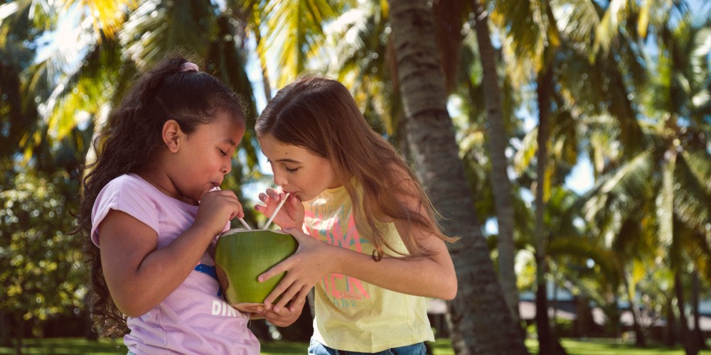 girls-sharing-coconut-milk-straws-mauritius-holidays-2022