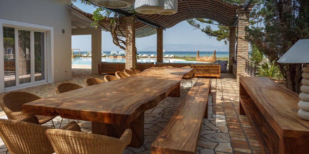 outdoor-dining-terrace-large-wooden-table-sea-views-villa-korali-greece