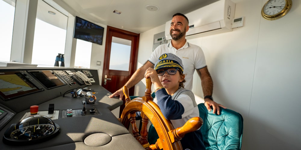 Child steers Ohana with captain superyacht croatia