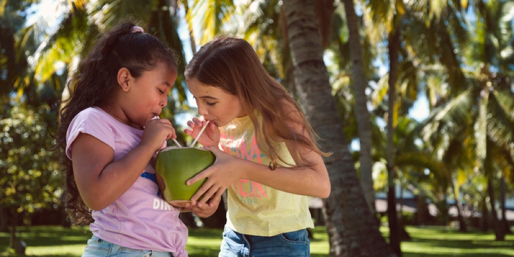 girls-sharing-coconut-drink-la-pirogue-resort-sunlife