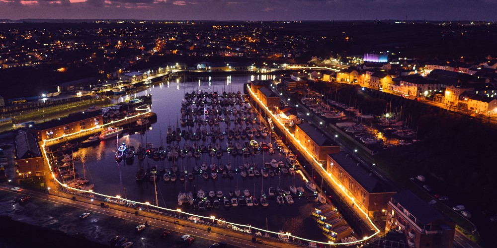Marina and waterfront lit up at night, Milford Haven, Wales