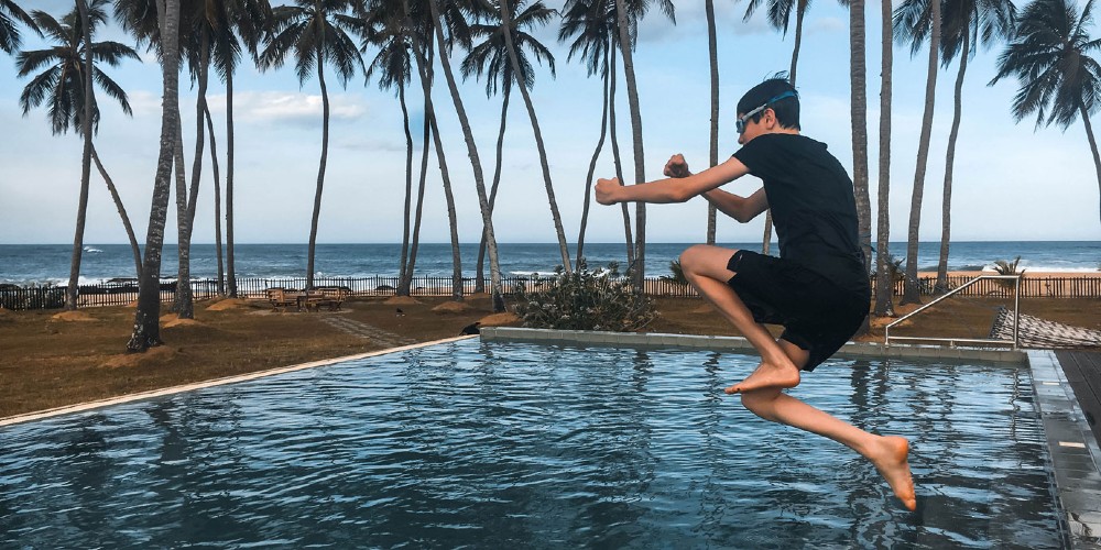 boy-jumping-in-swimming-pool-by-beach-sri-lanka-adventure-holiday