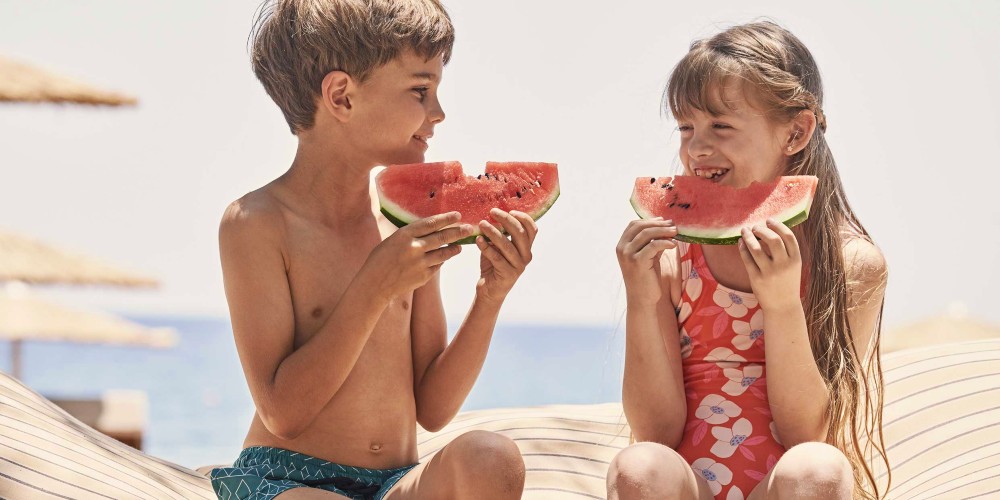 children-eating-watermelon-beach