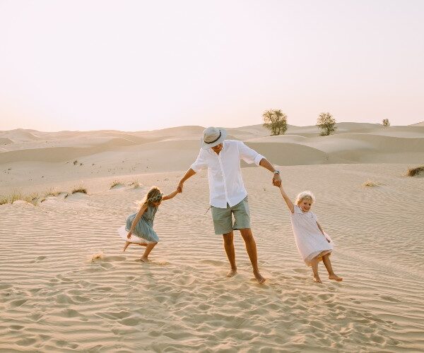 dubai-desert-father-with-daughters-playing-sand
