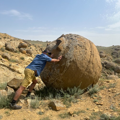 man-pushing-rock-valley-of-stone-balls