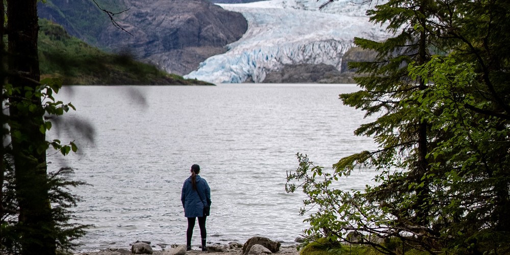 girl-on-shore-looking-over-water-at-mendenall-glacier