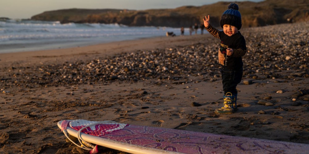 toddler-on-beach-in-winter-with-surf-board