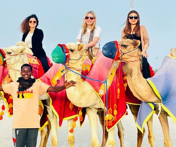 4-people-riding-camels-with-guide-deset-doha