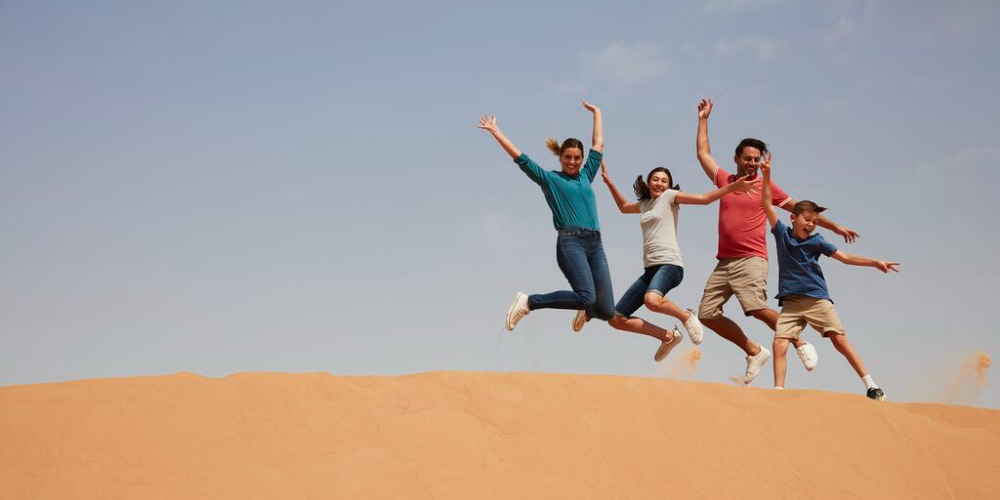 family-in-desert-leaping-with-joy