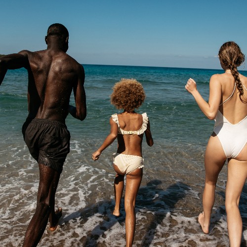 family-running-into-sea-greece