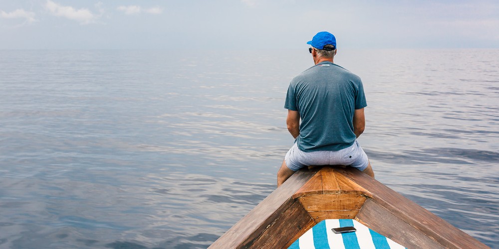 man-sitting-on-prow-of-yacht-rascal-voyages