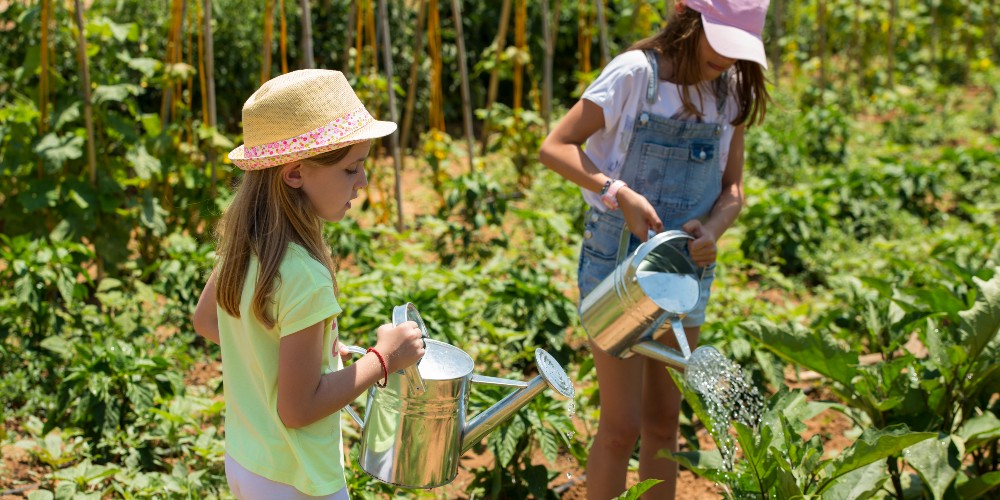 girls-watering-garden-costa-navarino-greece