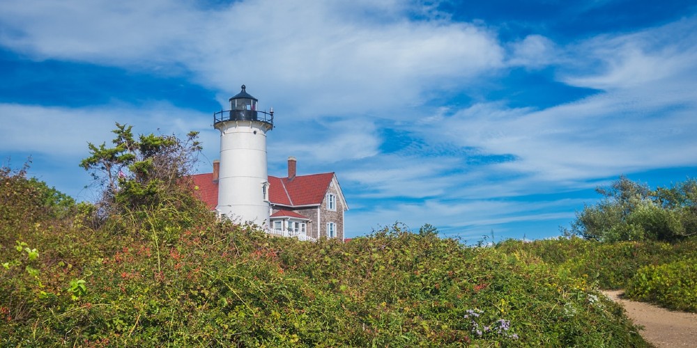 lighthouse-with-beach-house-surrounded-by-greenery-and-sands-massachusetts-2022