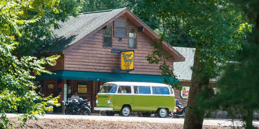green-vintage-volkswagen-campervan-outside-a-country-lodge-in-arkansas