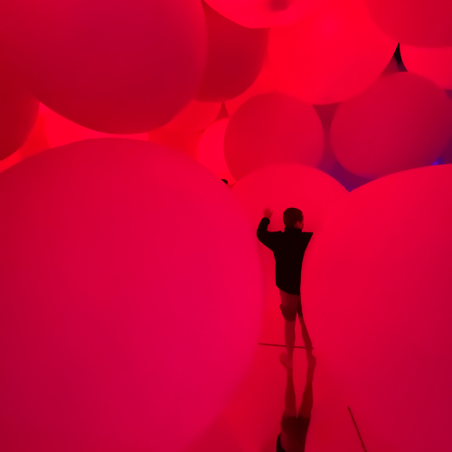 child-immersed-in-blood-red-balloons-teamlabs-museum-tokyo-japan-2023
