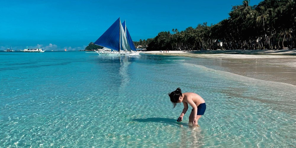 child-paddling-white-beach-philippines