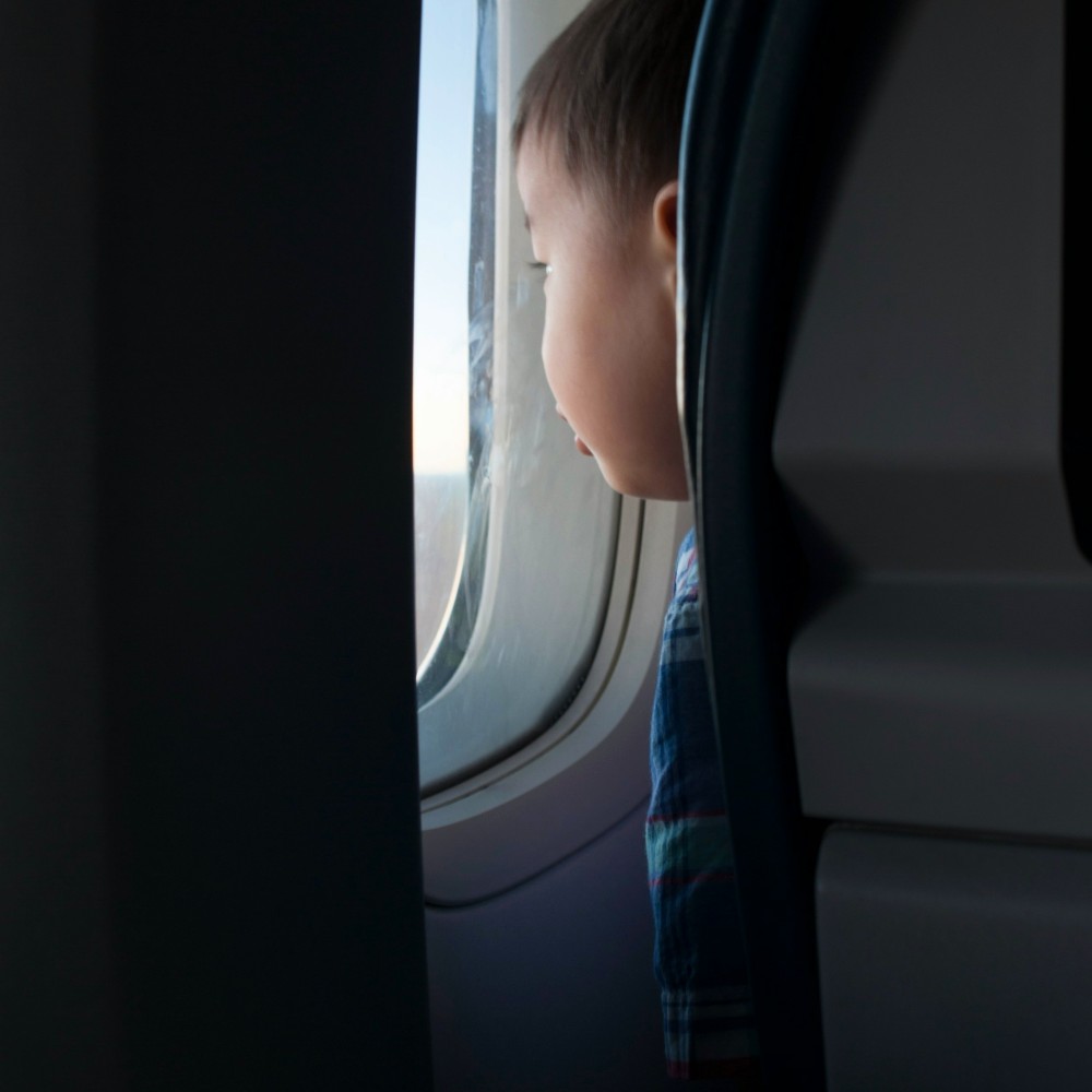 child-looking-out-flight-window