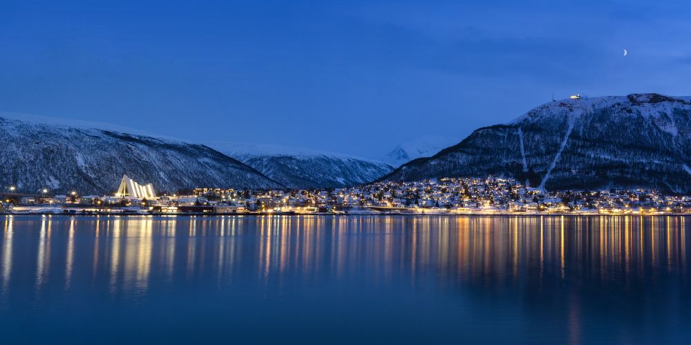 Tromso Norway city lights and mountains under a winter evening sky 