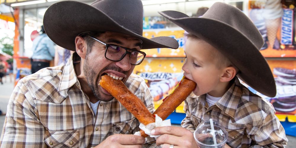 father-and-son-share-corndogs-calgary-stampede