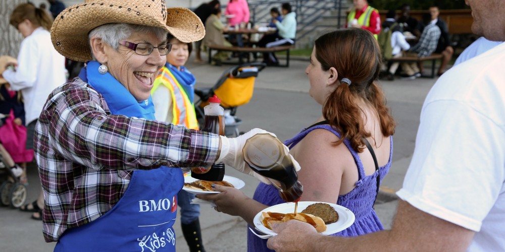 woman-pouring-syrup-on-pancakes